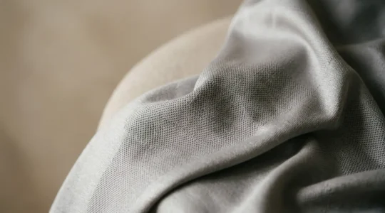 Détail textile d'un body technique minimaliste sur fond épuré évoquant l'univers du sport et de la mode urbaine