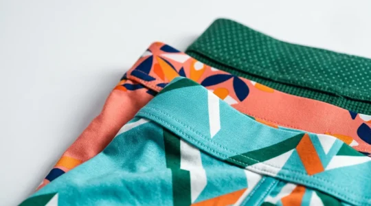 Gros plan sur des tissus de sous-vêtements masculins aux motifs variés et couleurs vives disposés avec soin