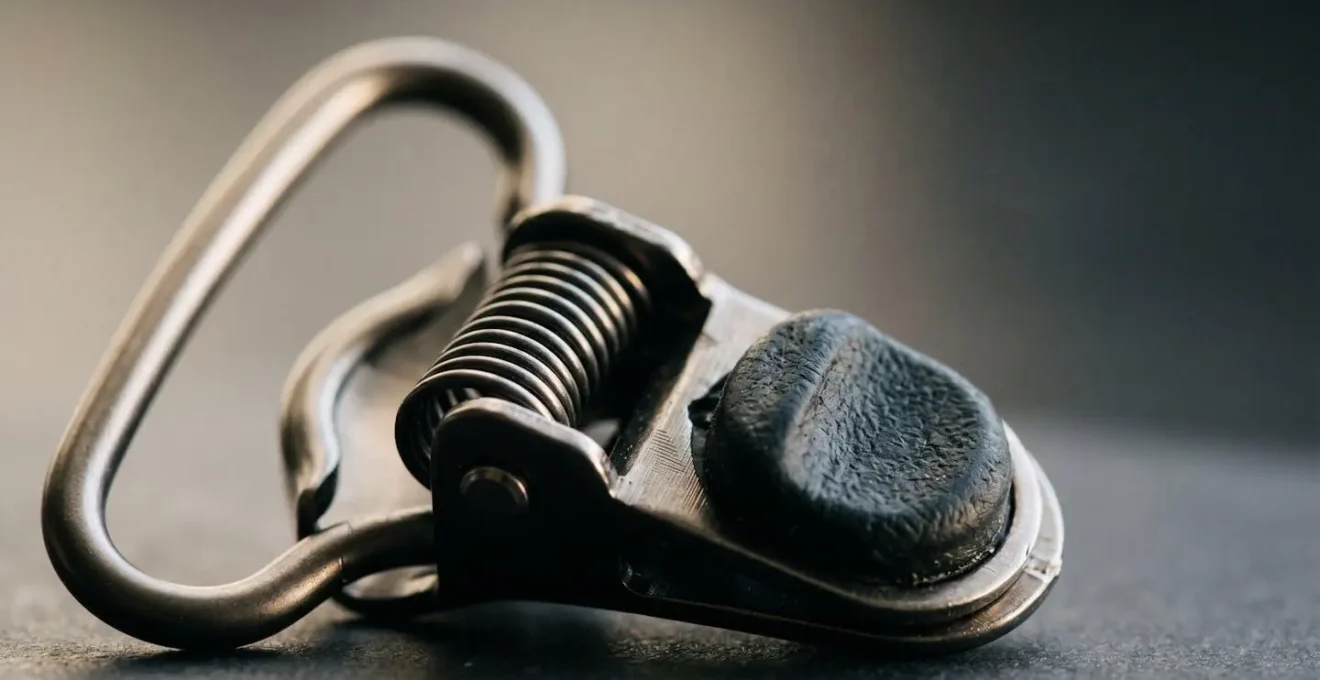 Gros plan sur un clip métallique de porte-jarretelles montrant la boucle arrondie et le mécanisme de fermeture