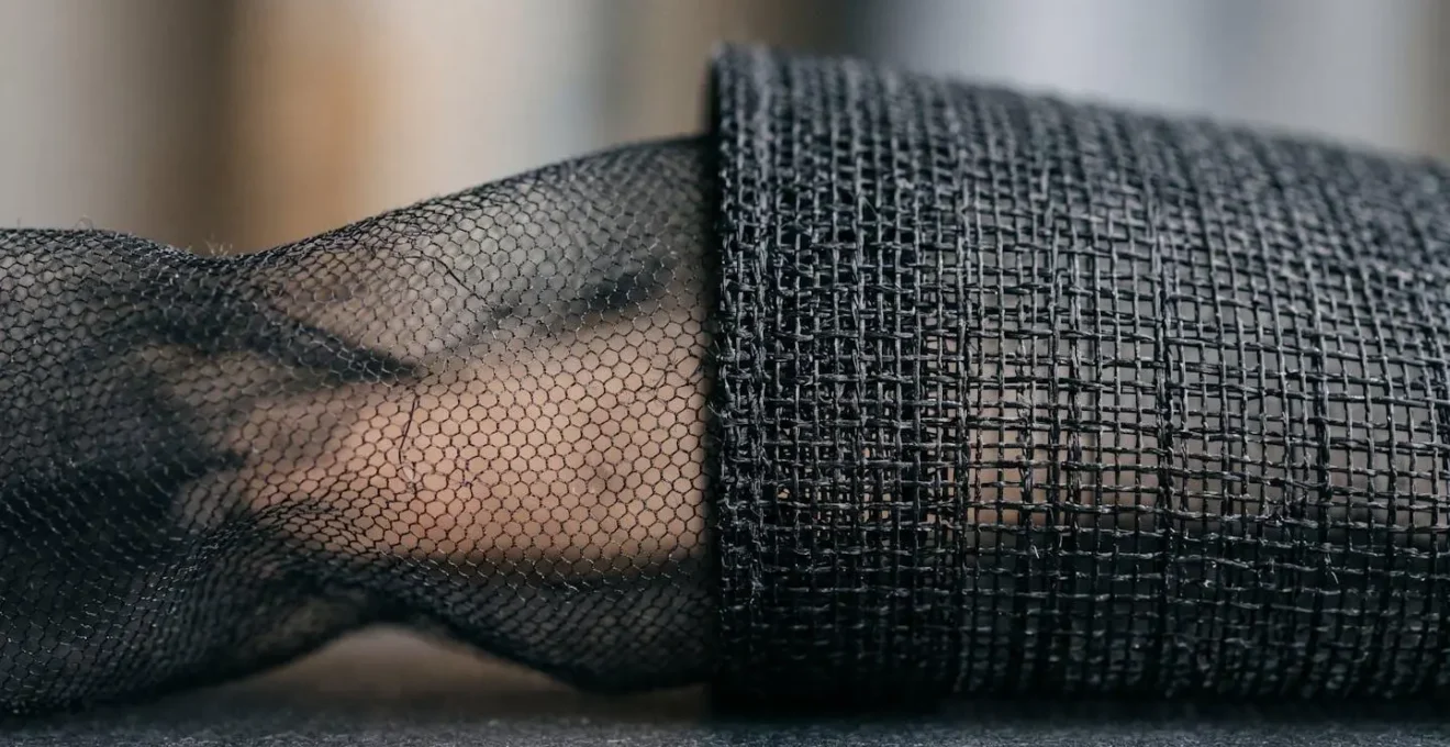 Détail macro des textures contrastées entre tulle doux et résille graphique en lingerie minimaliste